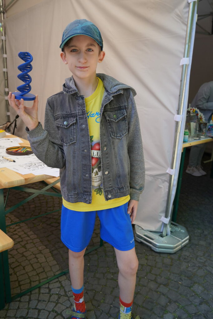 Návštevník podujatia My sme SAV 2024 na Hviezdoslavovom námestí v Bratislave s modelom DNA.