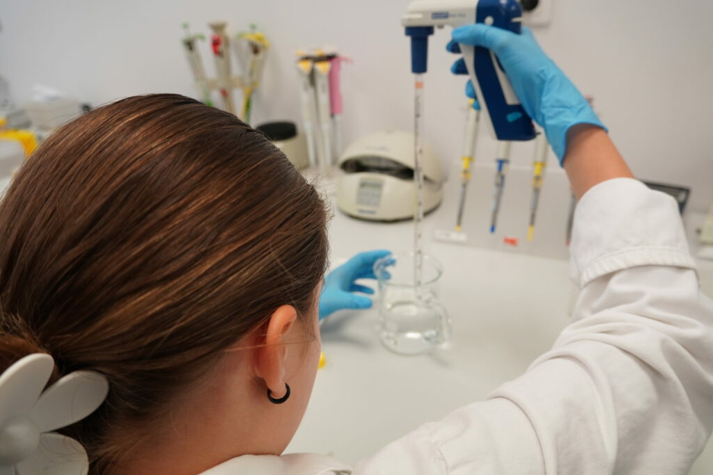 Letná škola mladých vedcov 2024, účastníčka pipetuje.