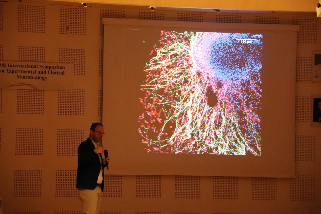 Dr. Alcino Silva stojí pred svojou prezentáciou.