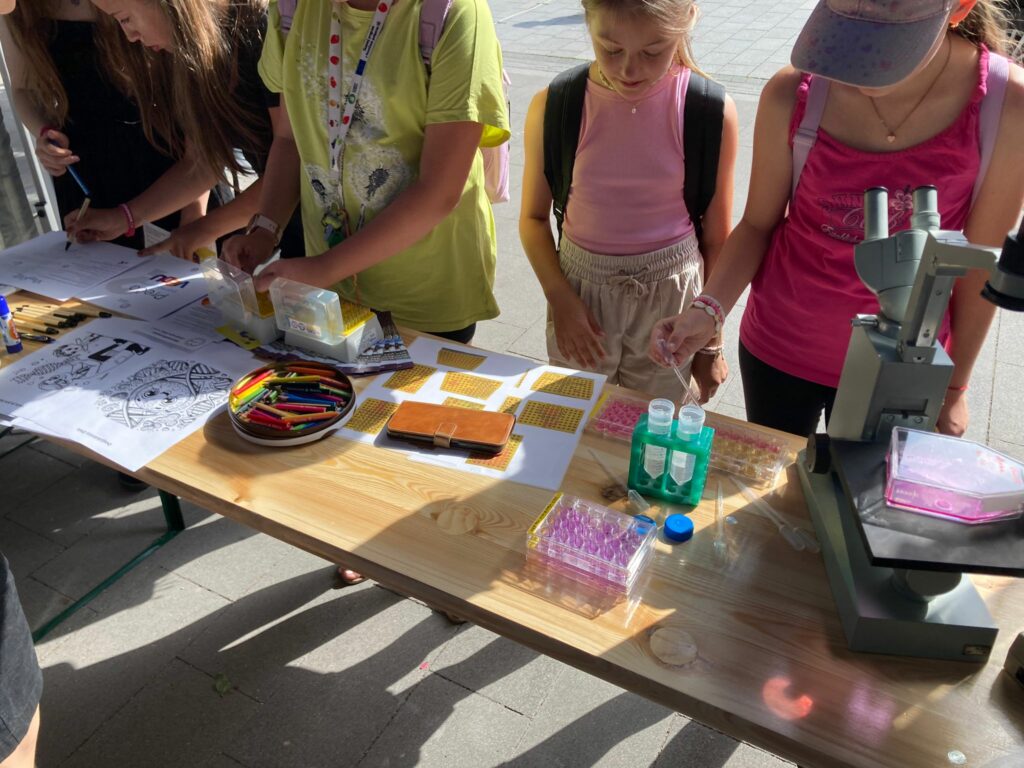 Návštevníci robia aktivity v stánku BMC SAV, v. v. i. na podujatí Víkend so SAV v Trnave.